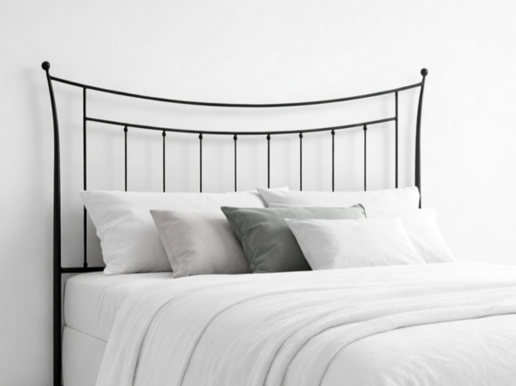 Cabecero de forja negro con diseño curvo y barrotes verticales en dormitorio minimalista
